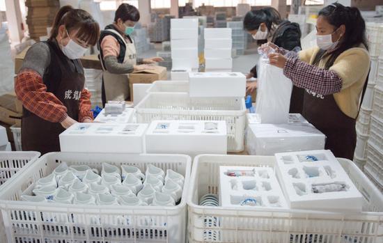 省泉州市永春县介福乡一家电商公司包装车间内,工人在包装陶瓷产品